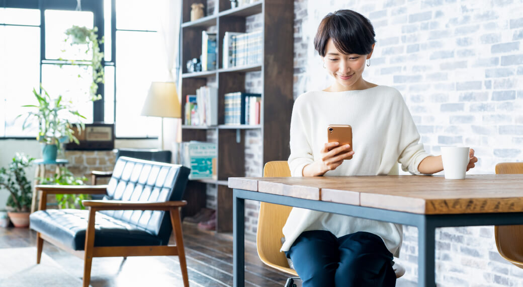 写真：スマホから来店予約する女性のイメージ画像