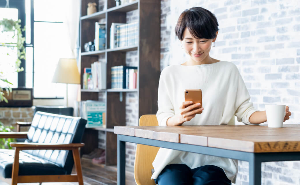 写真：スマホから来店予約する女性のイメージ画像